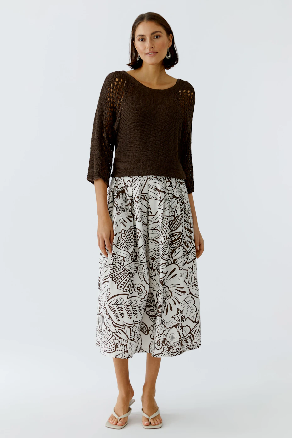 Floral patterned skirt: A woman in a flowy skirt with a white and brown floral design.
