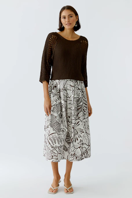 Floral patterned skirt: A woman in a flowy skirt with a white and brown floral design.