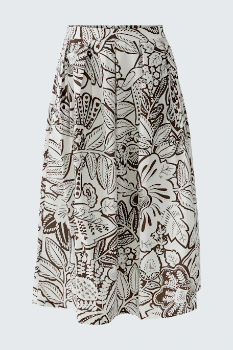 Floral patterned skirt: A woman in a flowy skirt with a white and brown floral design.