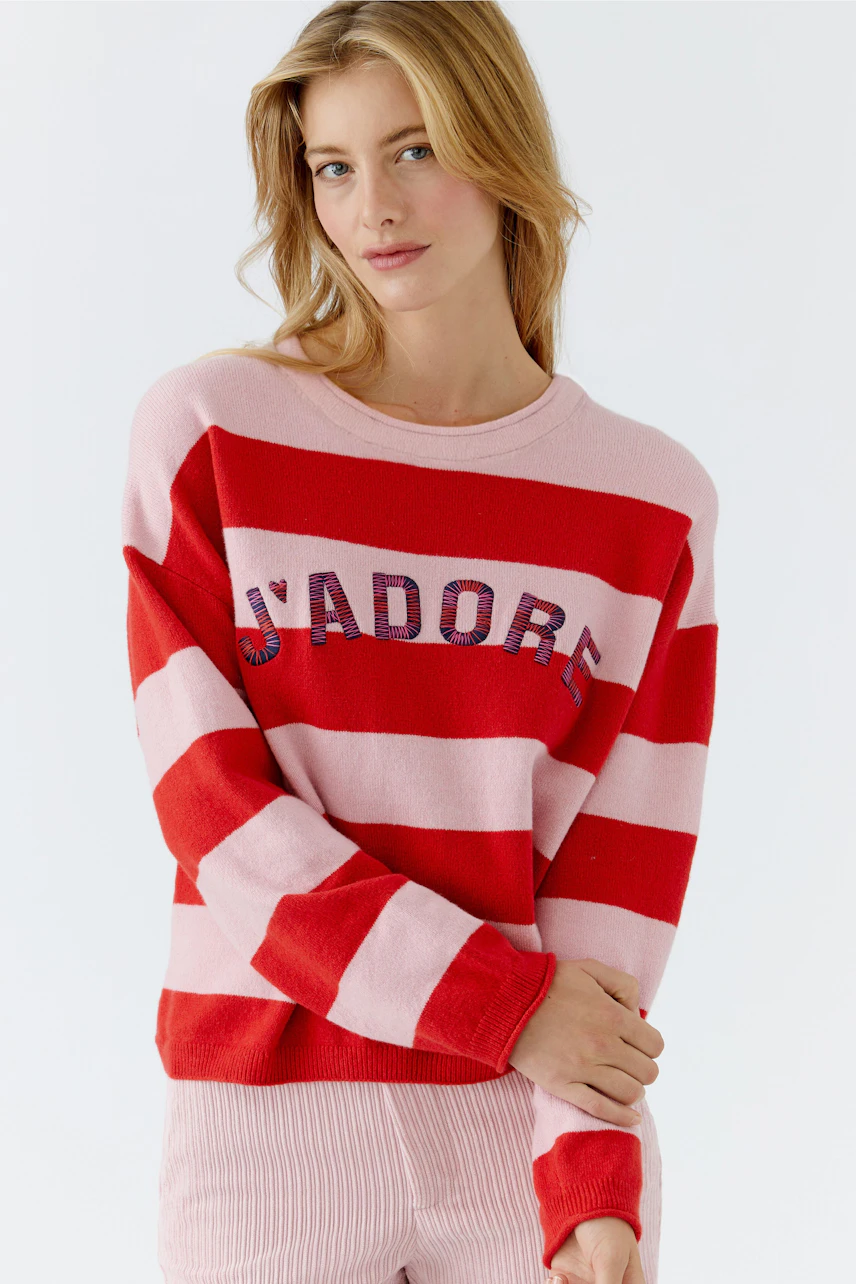 Casual women's pullover: Young woman in a red and pink striped pullover with 'J'adore' lettering.