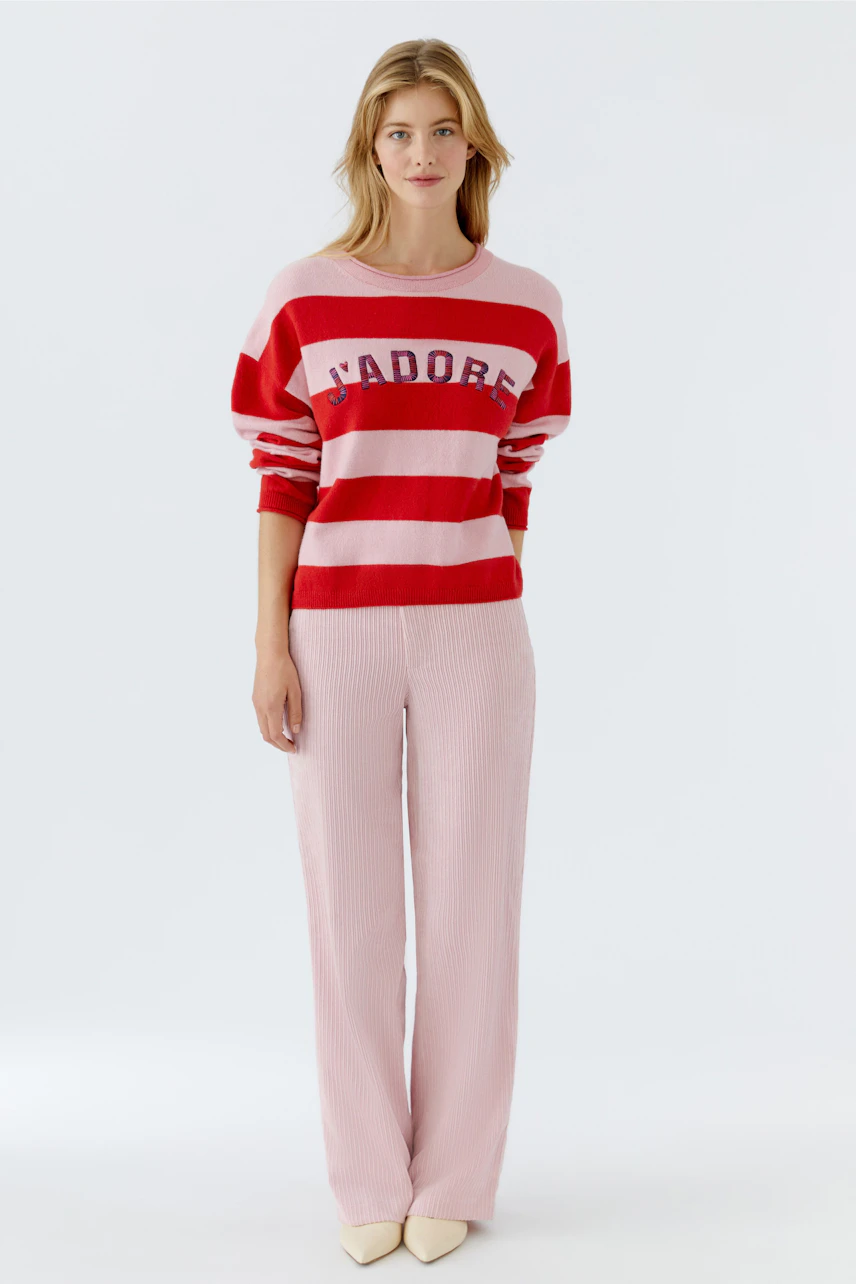 Casual women's pullover: Young woman in a red and pink striped pullover with 'J'adore' lettering.