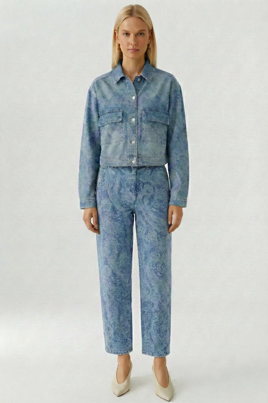 Denim jacket: Woman in a blue patterned jeans jacket and matching pants, standing confidently.