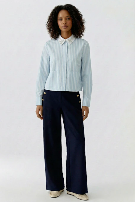 Gestreifte Damen-Bluse: Hellblaue Bluse mit weißen Streifen und Spitzenkragen, ohne Model abgebildet.