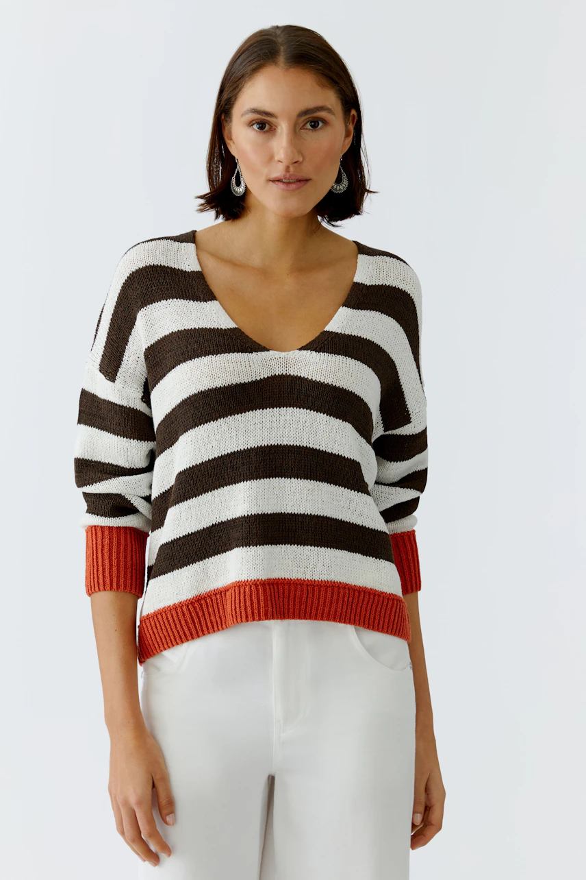 Casual women's pullover: A woman in a striped pullover with brown and white stripes and orange cuffs.