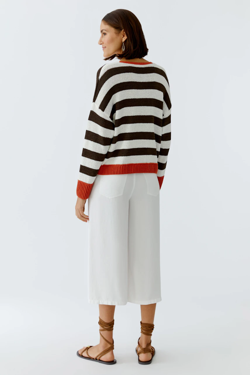 Casual women's pullover: A woman in a striped pullover with red accents, paired with white culottes.