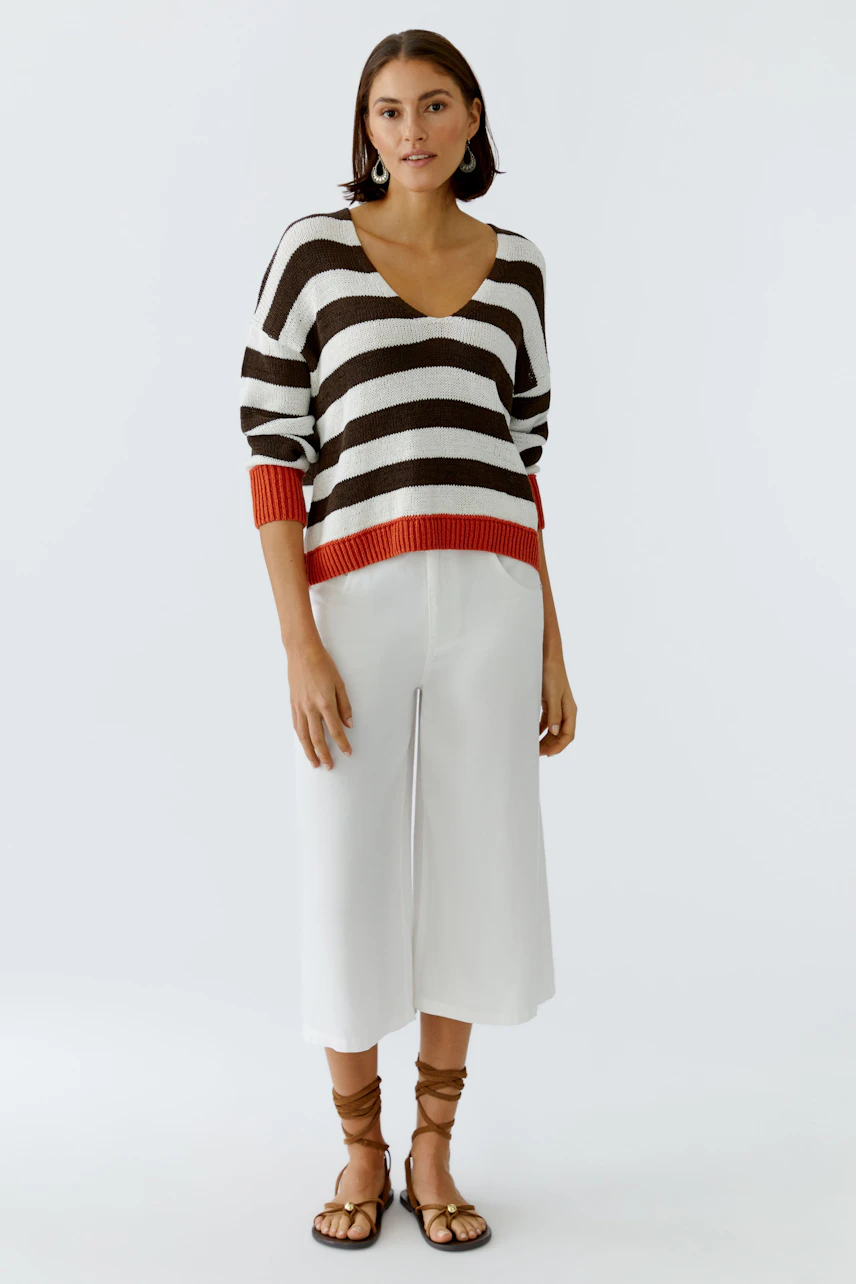 Casual women's pullover: A woman in a striped pullover with a V-neck and relaxed fit.