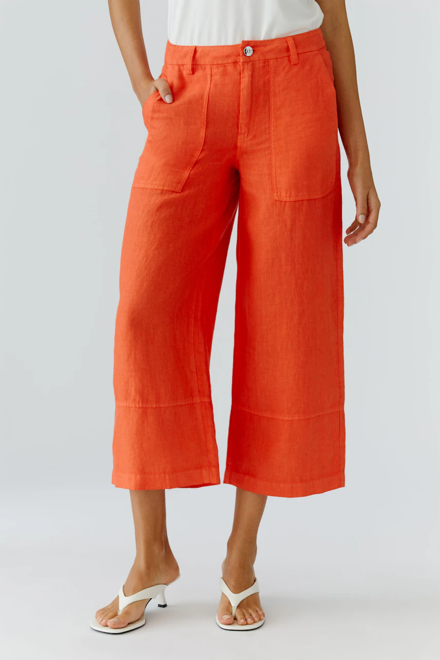 Casual women's pants: A woman in bright orange wide-leg pants with pockets stands confidently.