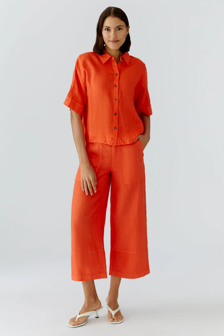Casual women's pants: A woman in bright orange wide-leg pants with a matching shirt, exuding a relaxed vibe.