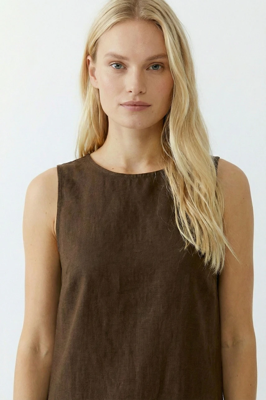 Casual A-line dress: Woman in a brown sleeveless dress with a simple design, showcasing a relaxed style.