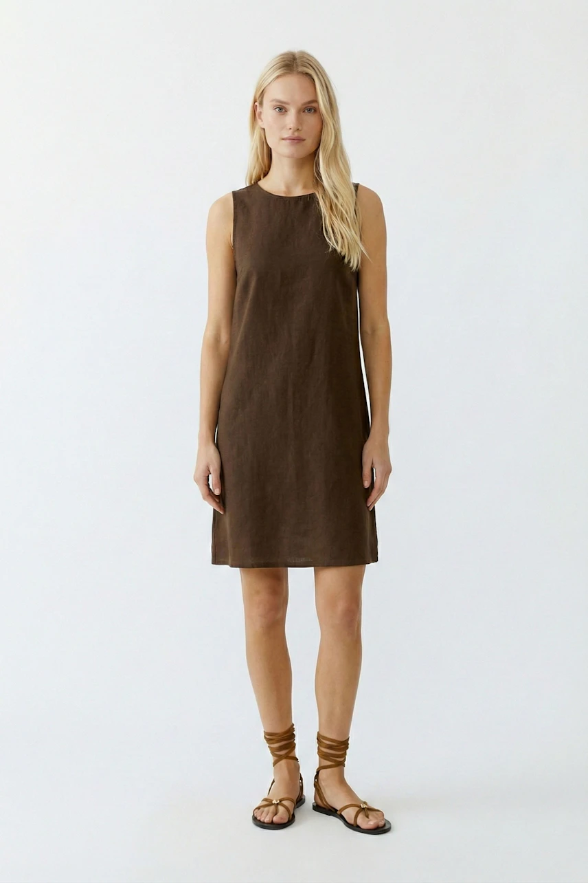 Casual A-line dress: Woman in a brown sleeveless dress, standing confidently with sandals.