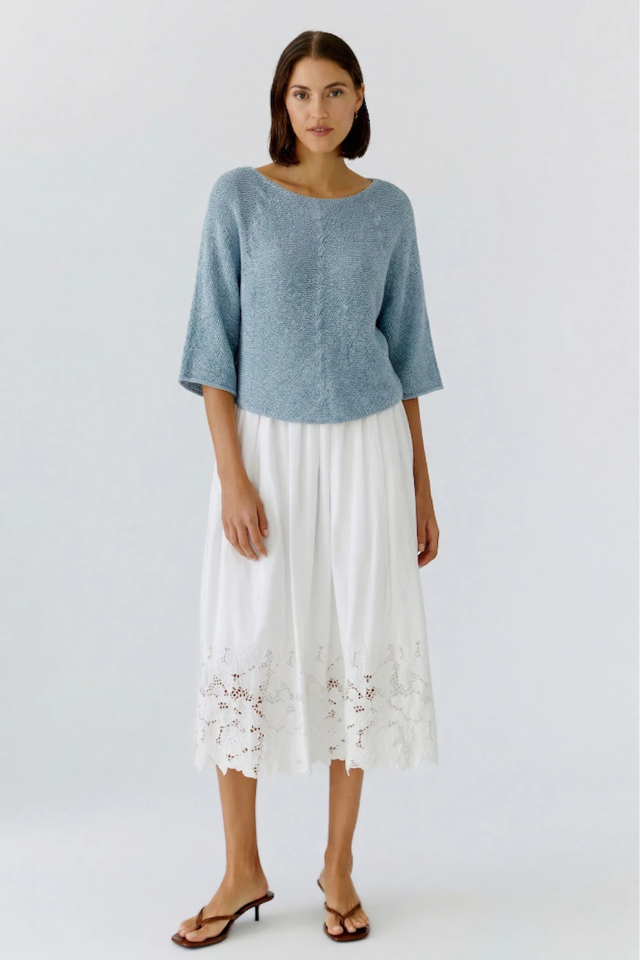 Lightweight white pleated skirt with lace detailing, perfect for casual summer outings.