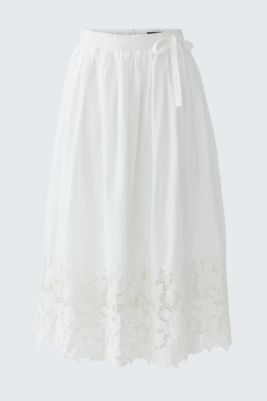 Lightweight white pleated skirt with lace detailing, perfect for casual summer outings.