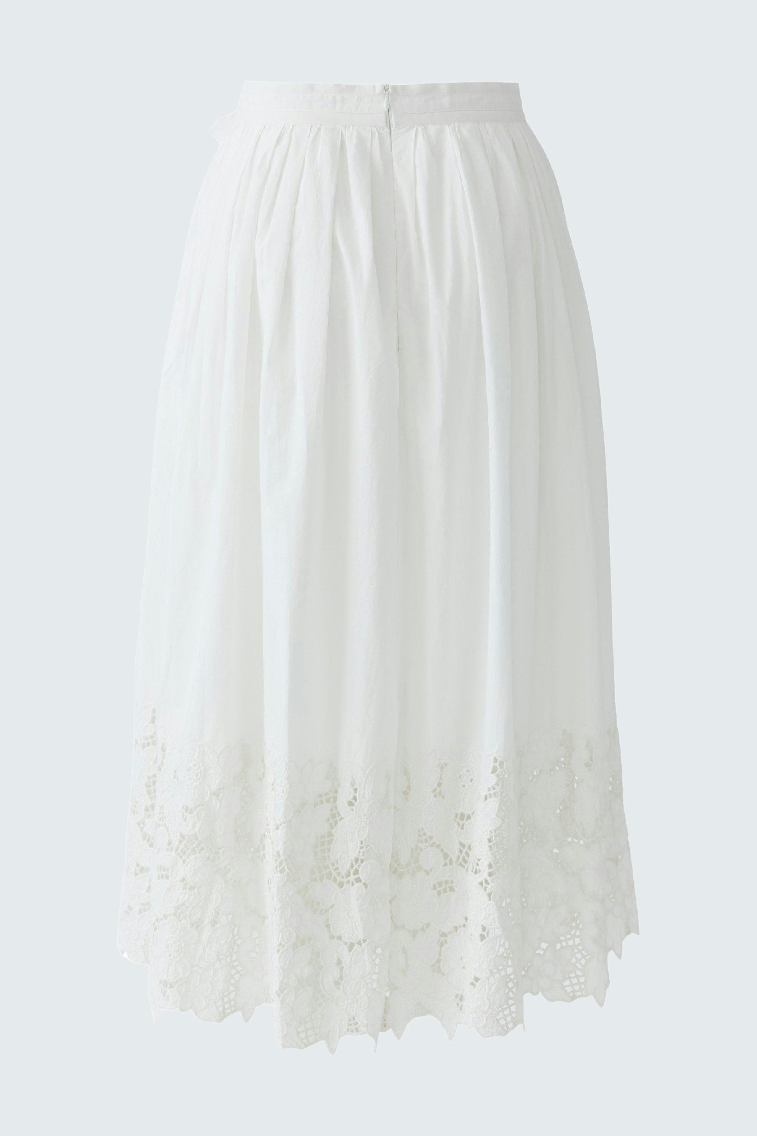 Lightweight white pleated skirt with lace detailing, worn by a woman.