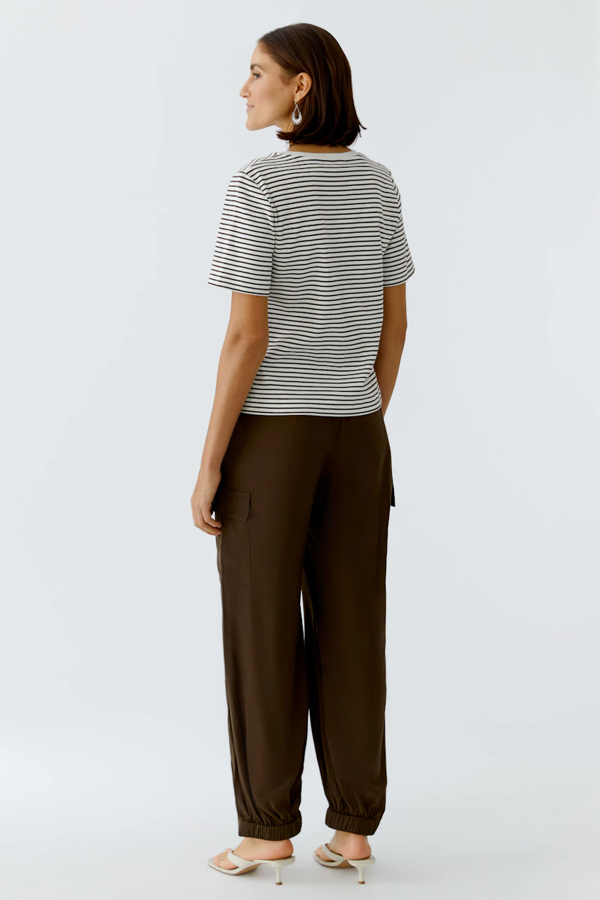 Casual women's T-shirt: Young woman in a striped tee paired with relaxed-fit pants.