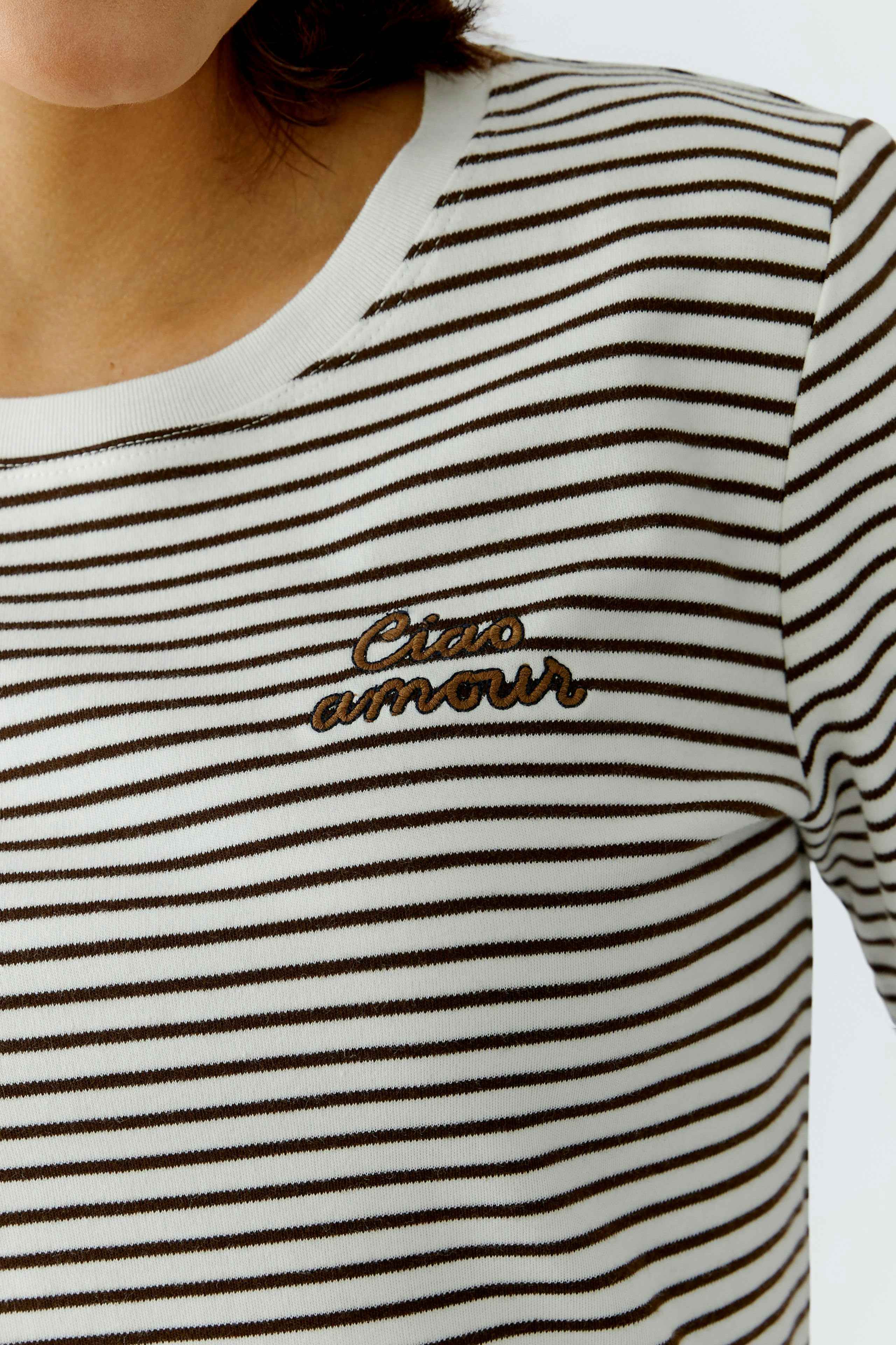 Damen-T-Shirt: Frau trägt gestreiftes Shirt mit "Ciao amour" Stickerei.