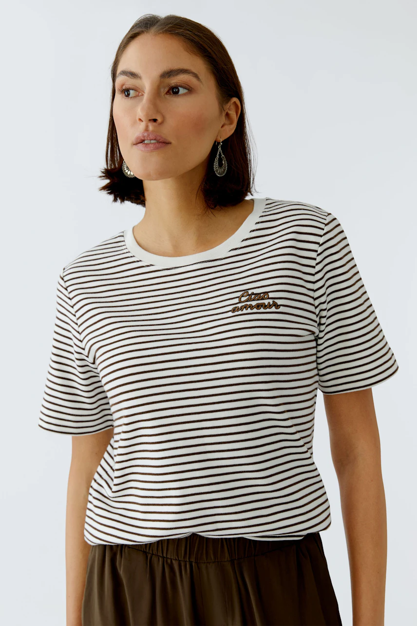 Casual women's T-shirt: Young woman in a striped tee with a playful design, exuding a relaxed vibe.