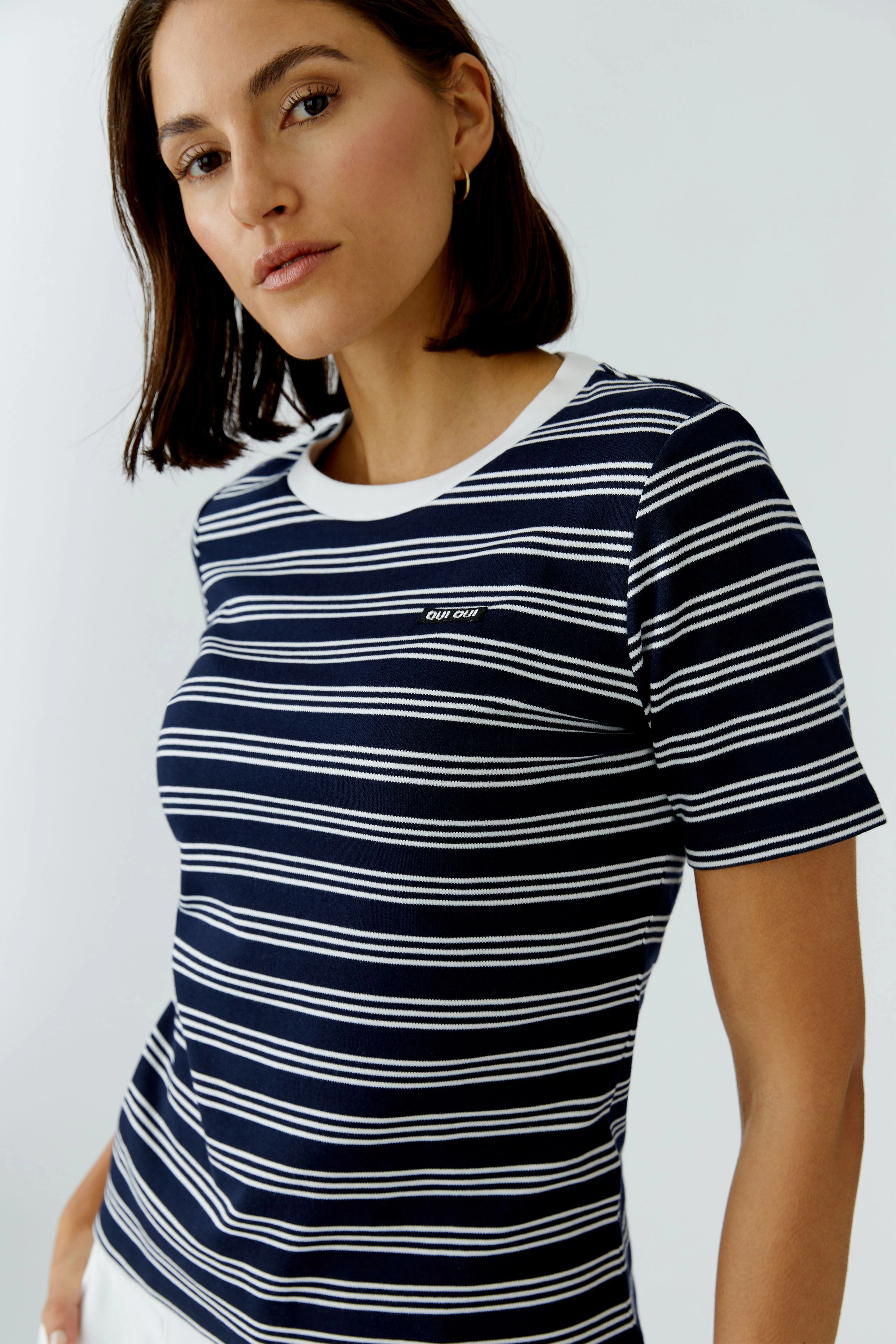 Casual women's T-shirt: Young woman in a navy striped tee with a round neckline, looking confidently.