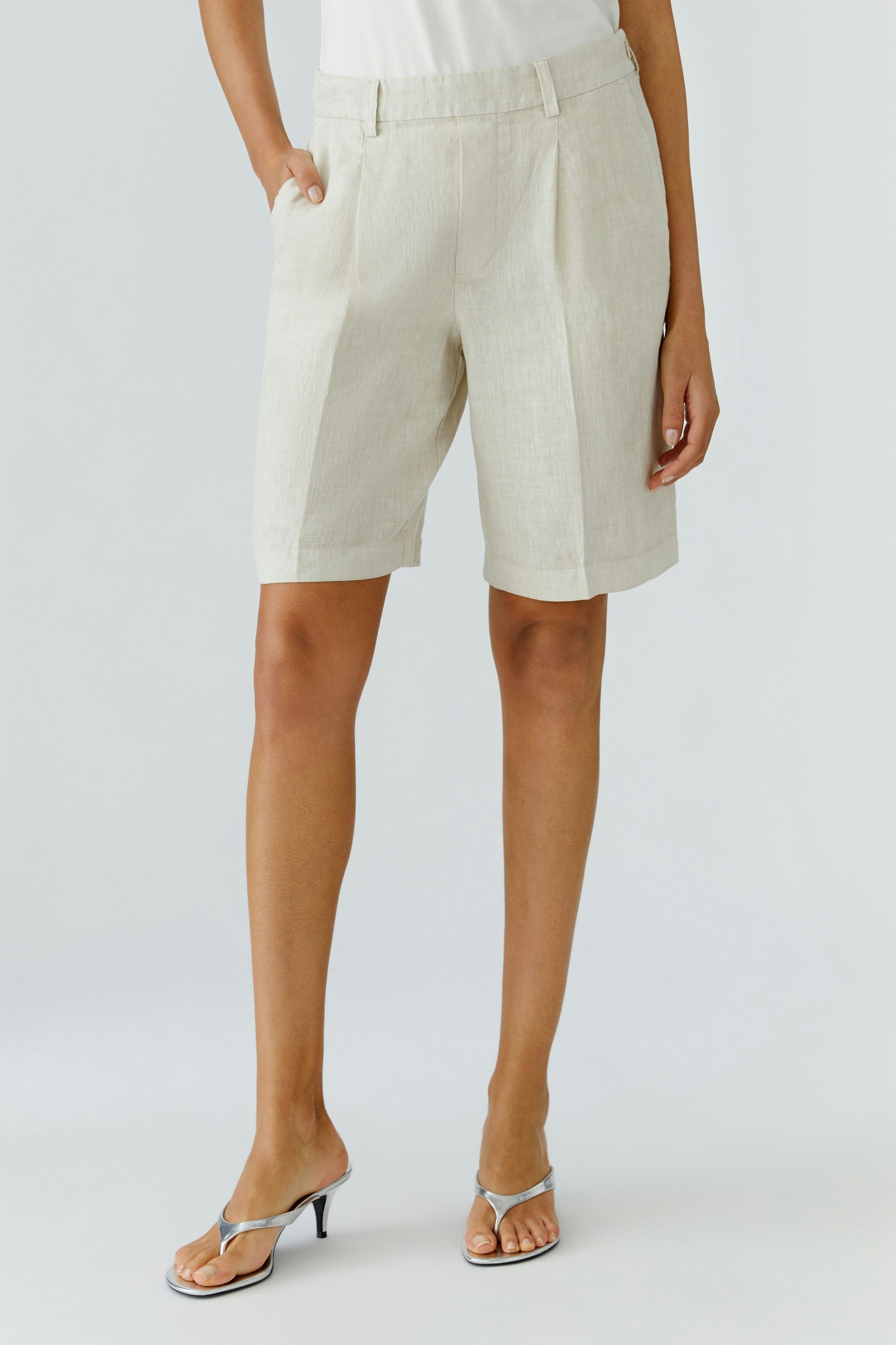 Bequeme Damen-Bermuda: Frau in hellen Shorts mit lässigem Schnitt und seitlichen Taschen.