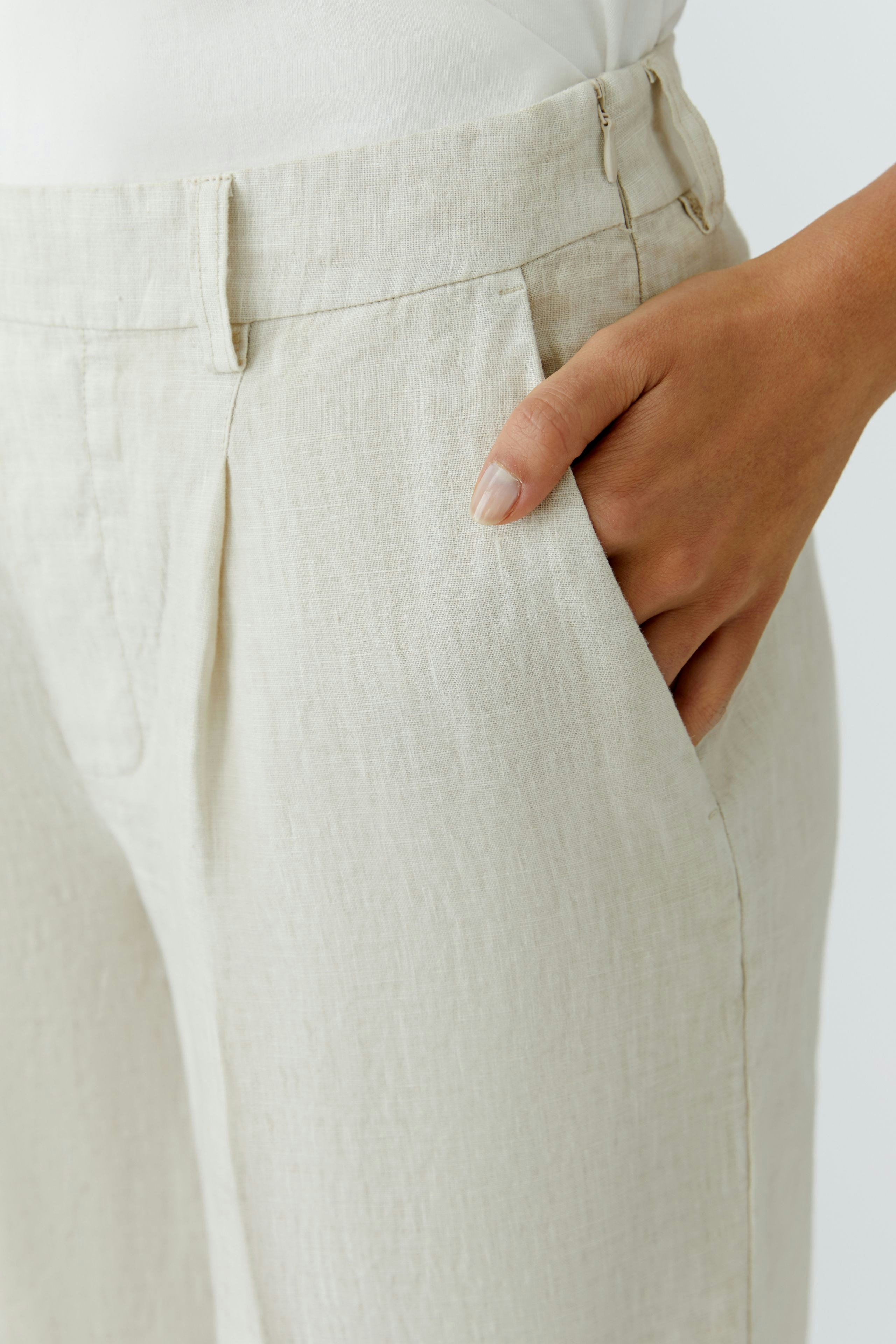 Bequeme Damen-Bermuda: Frau trägt helle, lockere Bermuda mit praktischen Taschen und lässigem Schnitt.