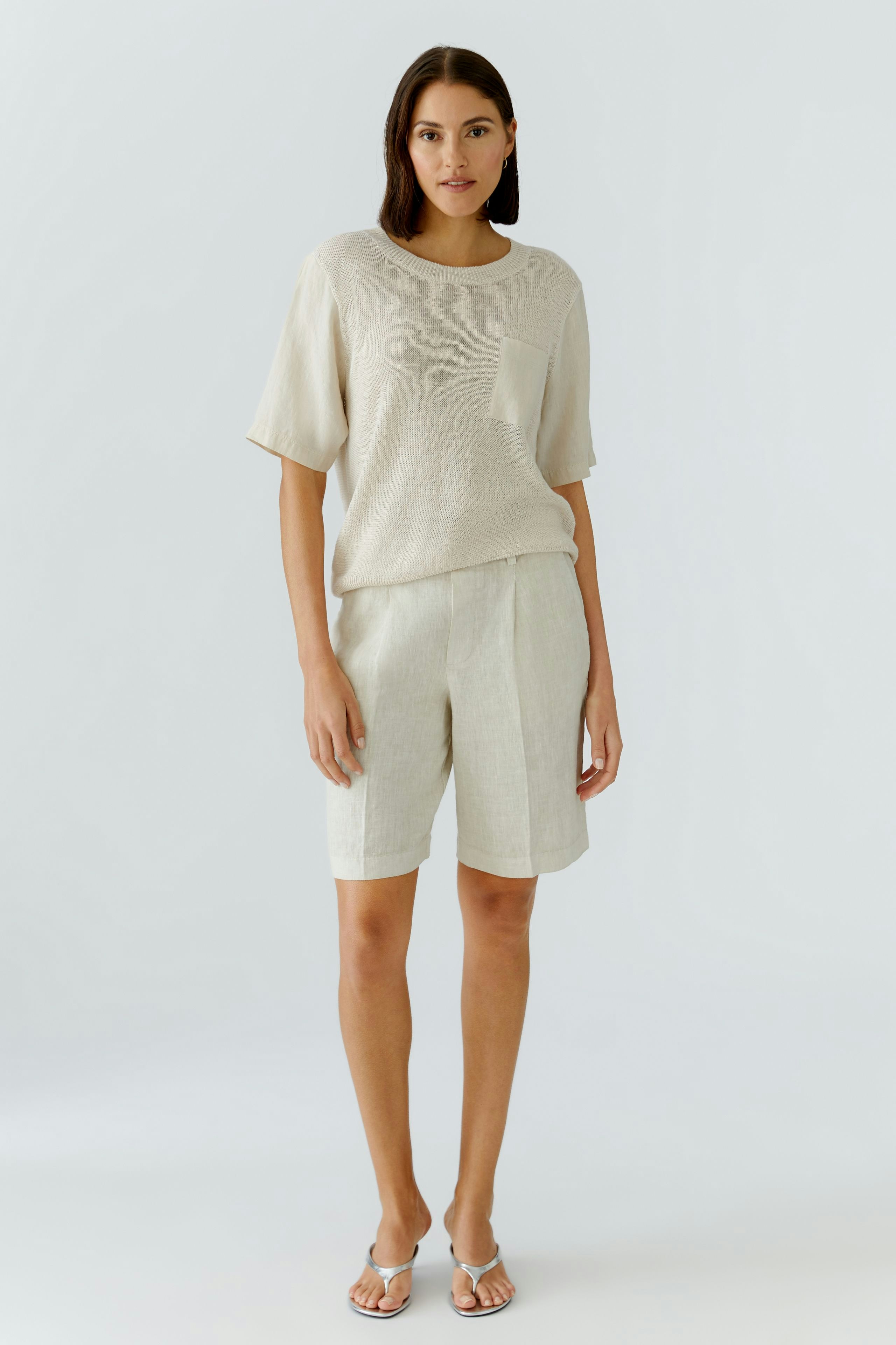 Bequeme Damen-Bermuda: Frau in hellen Shorts mit lässigem Oberteil und seitlicher Tasche.