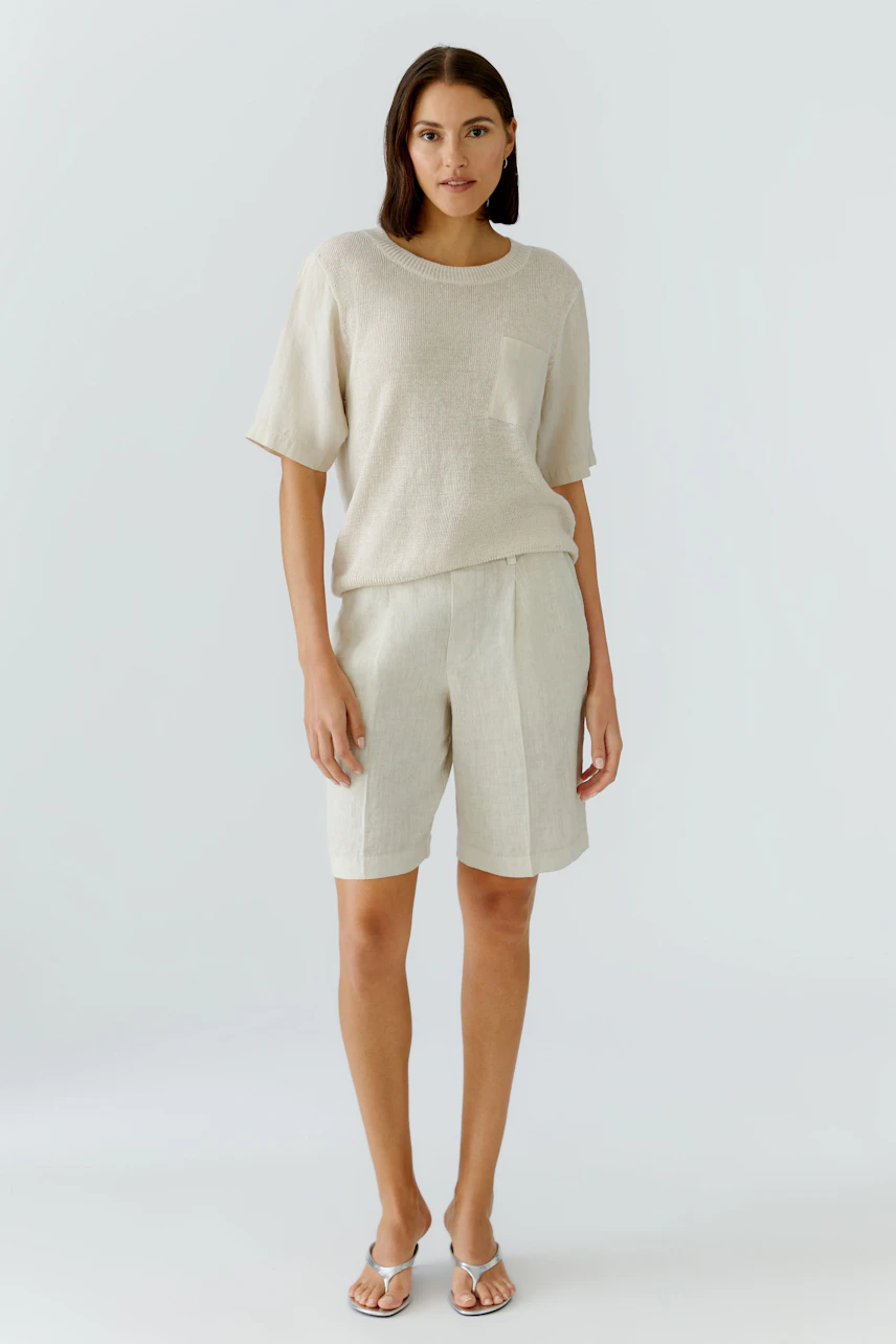 Bequeme Damen-Bermuda: Frau in hellen Shorts mit lässigem Oberteil und seitlicher Tasche.