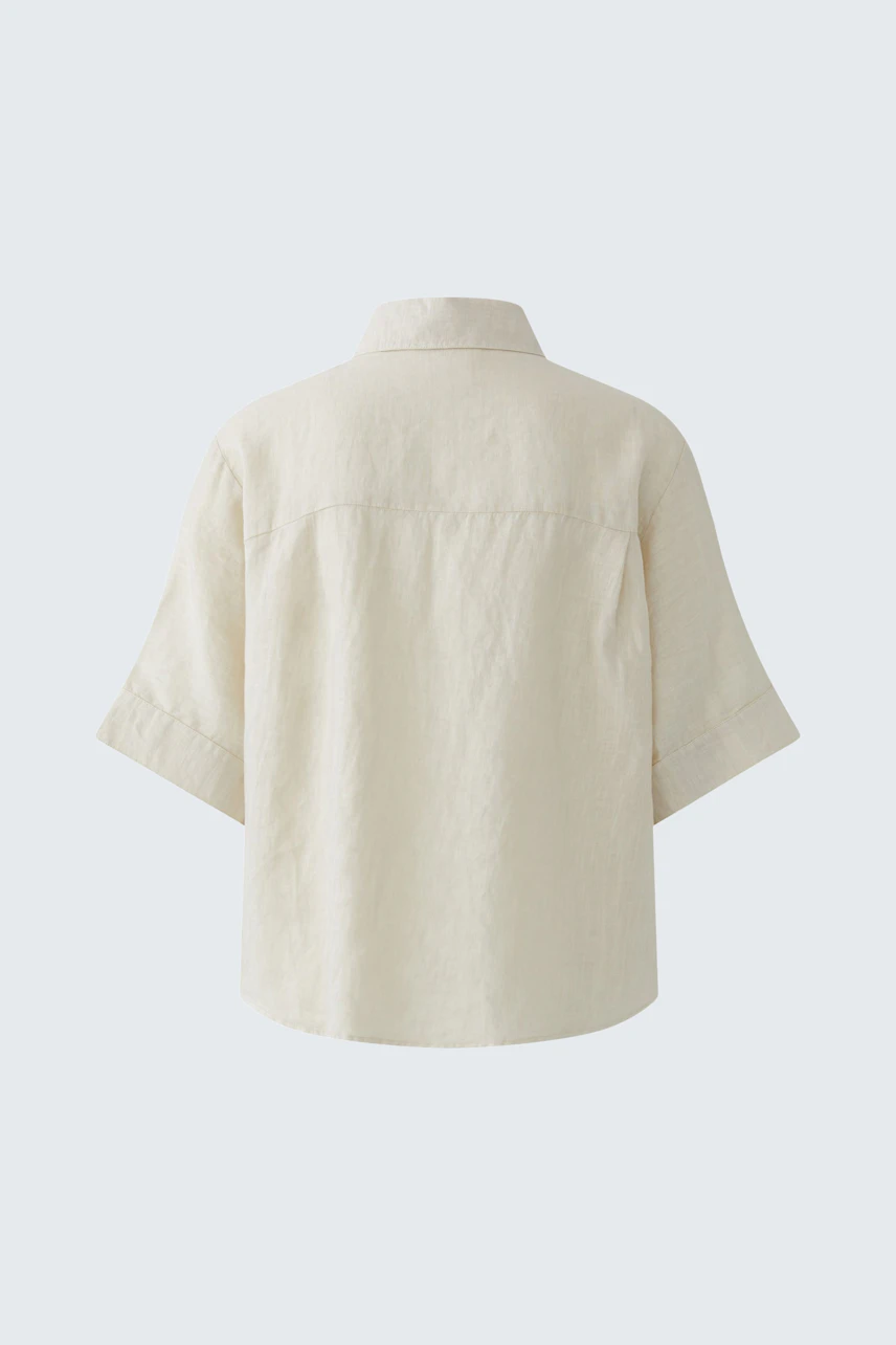 Casual women's blouse: Back view of a light-colored, short-sleeve blouse with a relaxed fit.