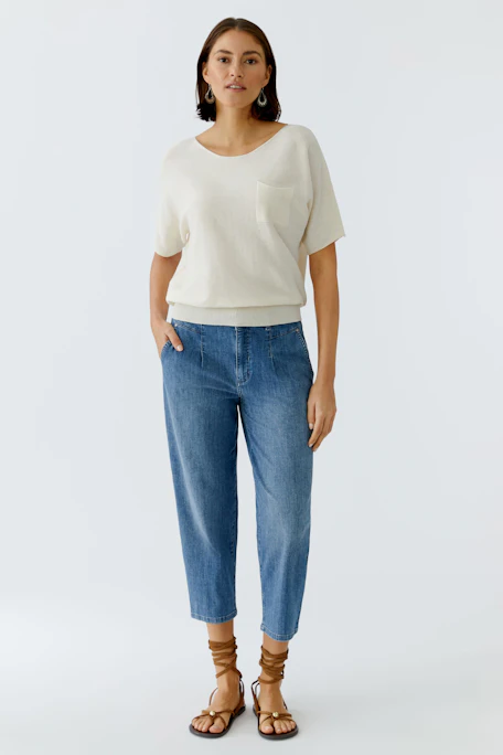 Casual women's pullover in soft cream color with short sleeves and a pocket detail.