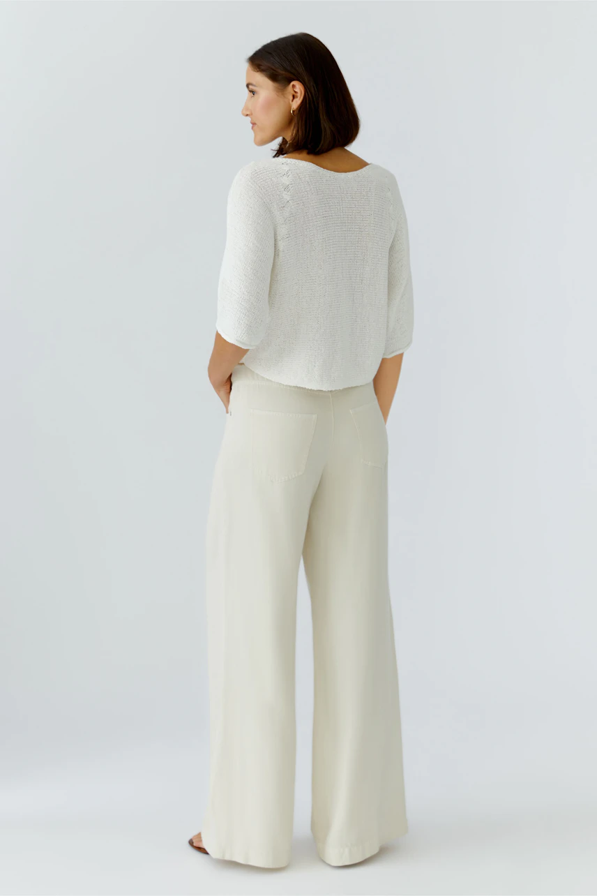 Casual women's pullover: A woman in a light, textured pullover with three-quarter sleeves and relaxed fit.