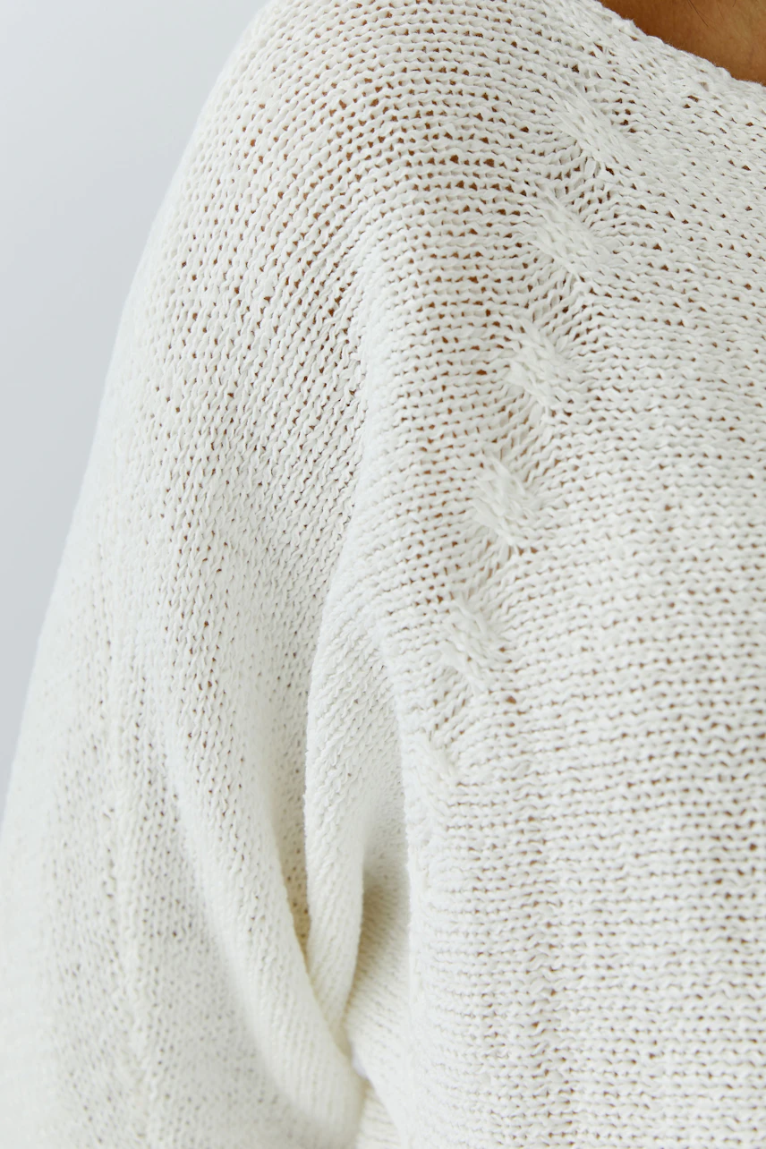 Casual women's pullover: Close-up of a woman in a light knitted pullover with a relaxed fit.