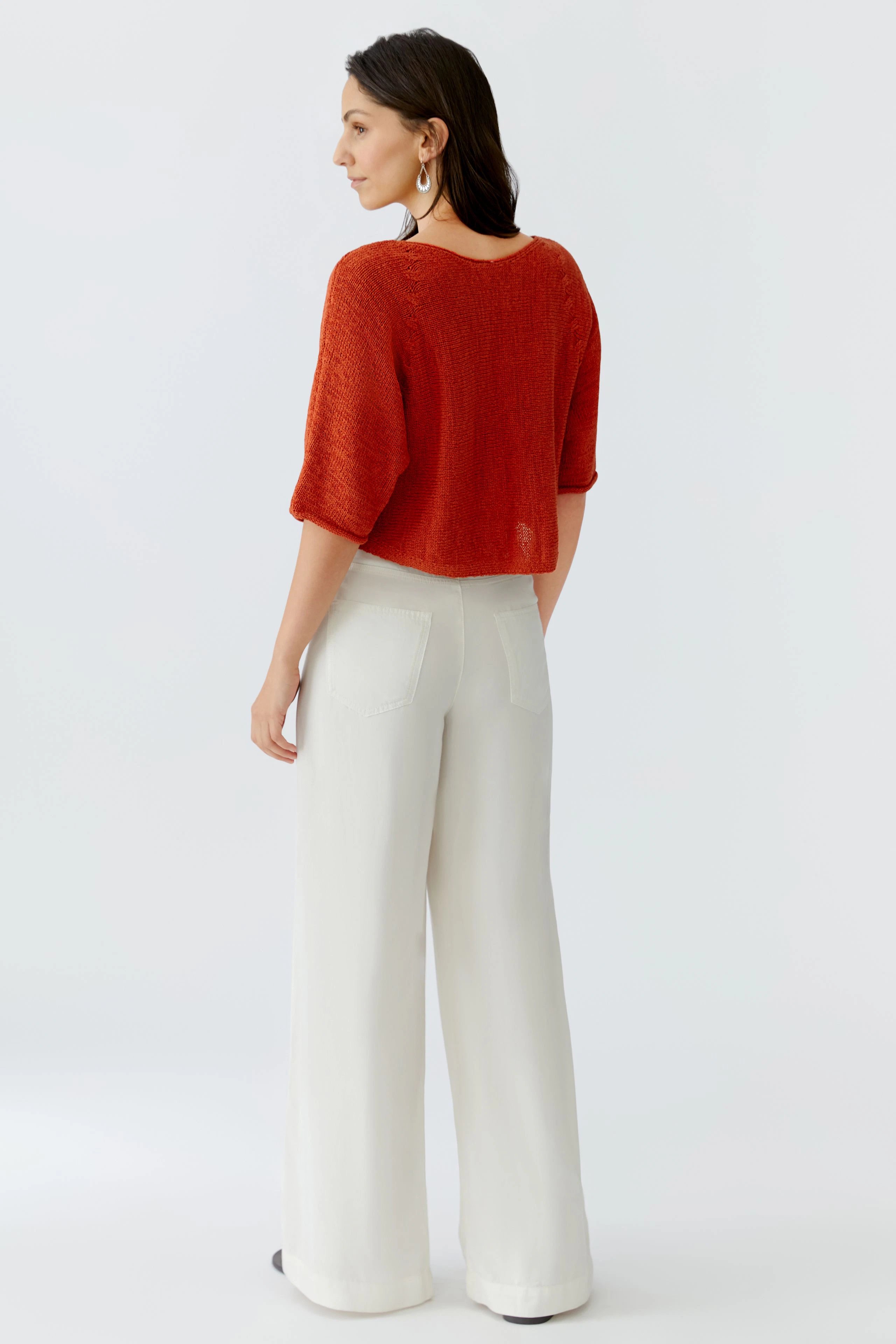 Damen-Pullover: Frau in rotem, lässigem Strickpullover mit kurzen Ärmeln und weitem Schnitt.