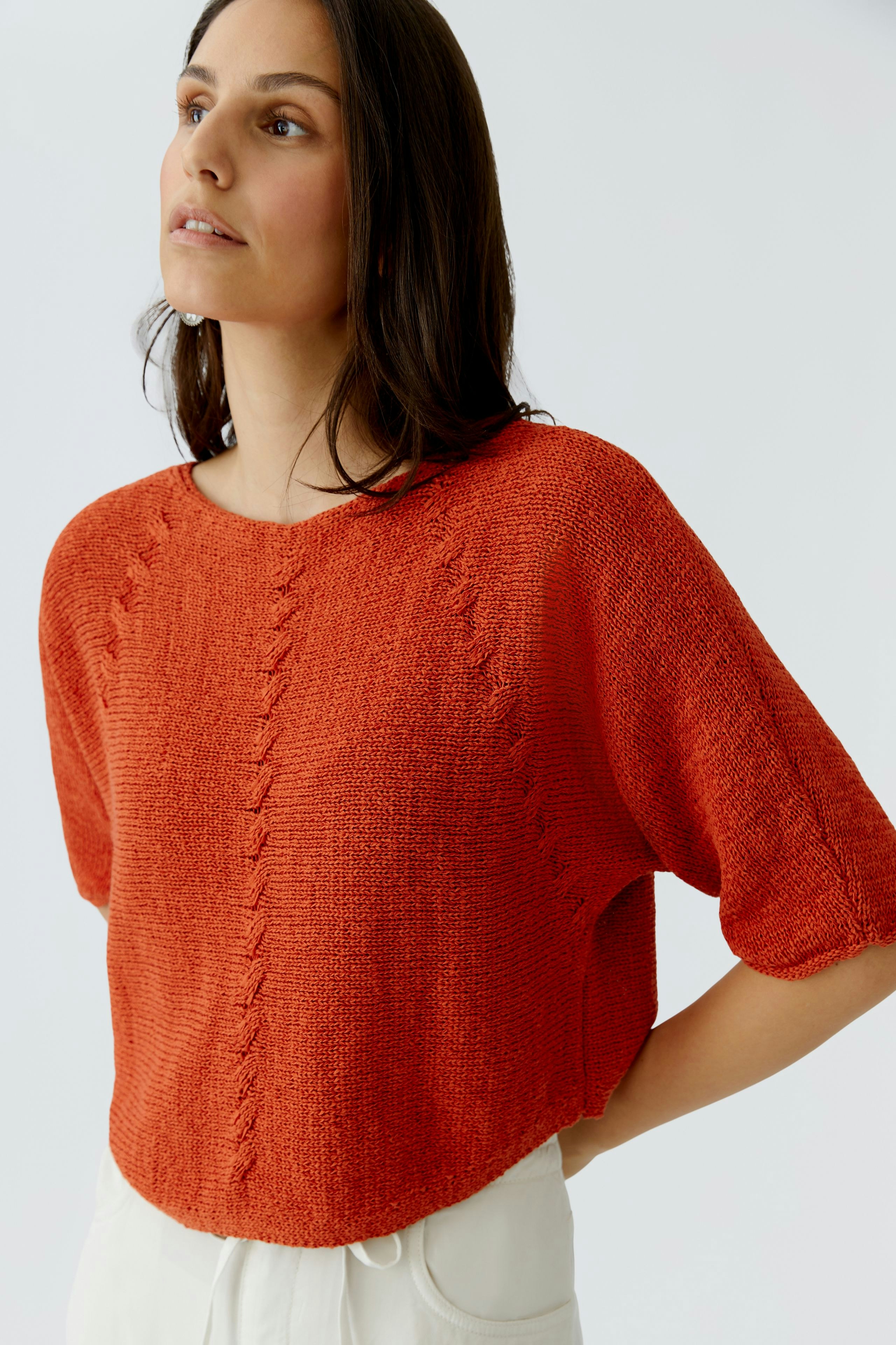 Damen-Pullover in leuchtendem Orange: Frau trägt einen lässigen, weiten Strickpullover mit kurzen Ärmeln.
