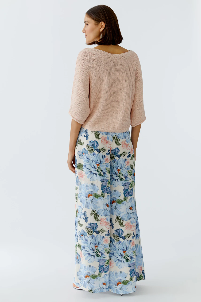 Damen-Pullover in zartem Rosé, lässig geschnitten, kombiniert mit floralen Hosen.
