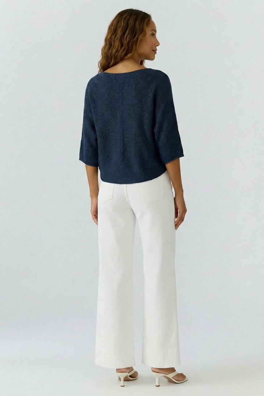 Casual women's pullover: A woman in a navy blue pullover with three-quarter sleeves, paired with white pants.