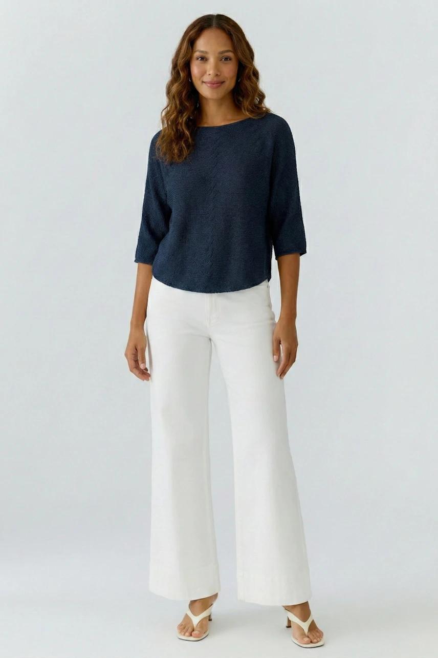 Casual women's pullover: A woman in a navy pullover paired with white wide-leg pants, smiling confidently.