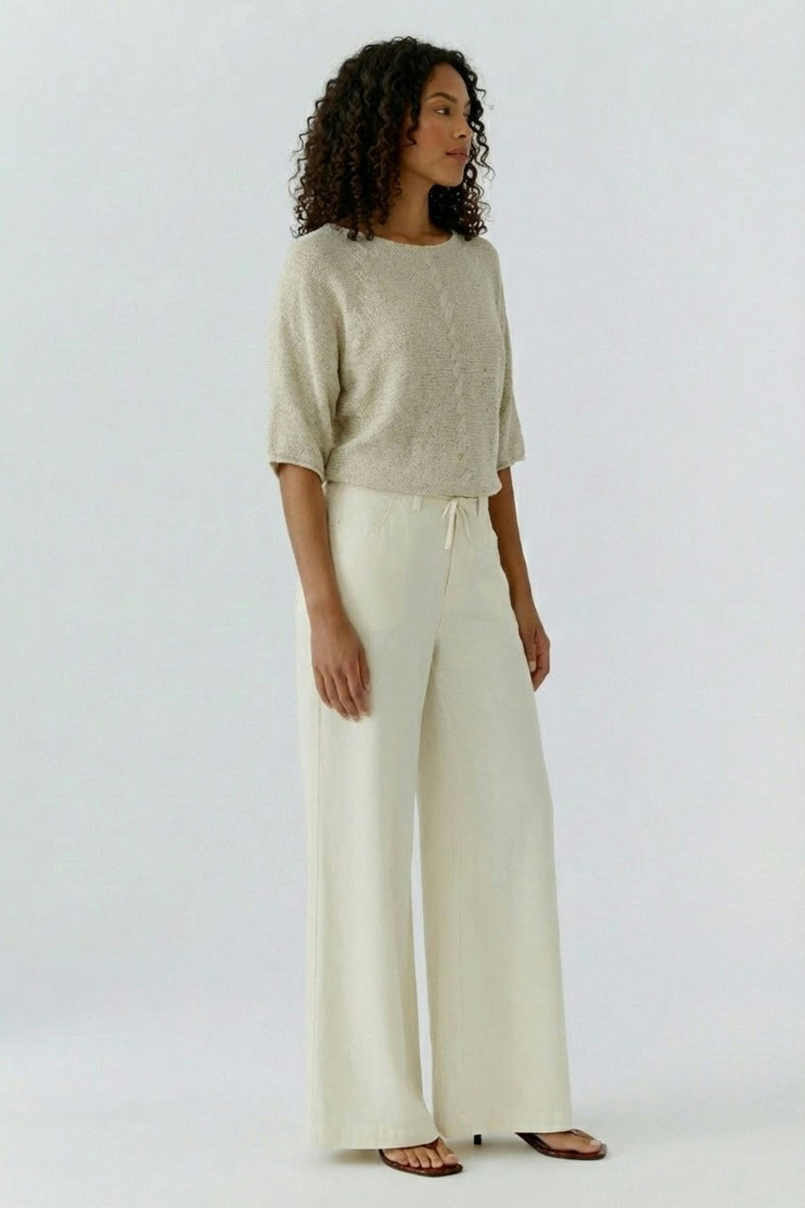 Bequemer Damen-Pullover in hellem Beige, lässig kombiniert mit weiten, hellen Hosen.