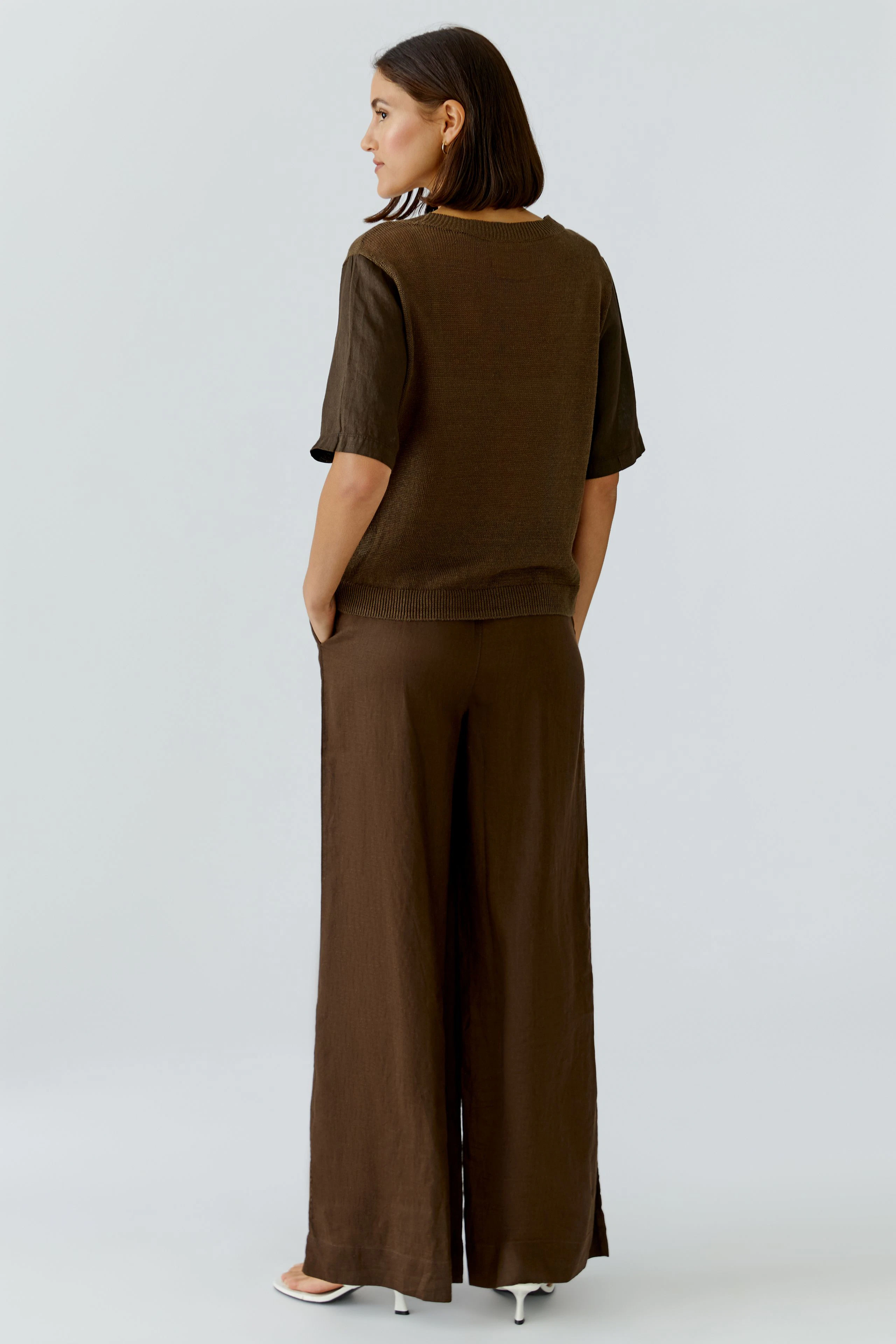 Damen-Pullover: Frau in braunem, lässigem Strickpullover mit kurzen Ärmeln und lockerer Passform.