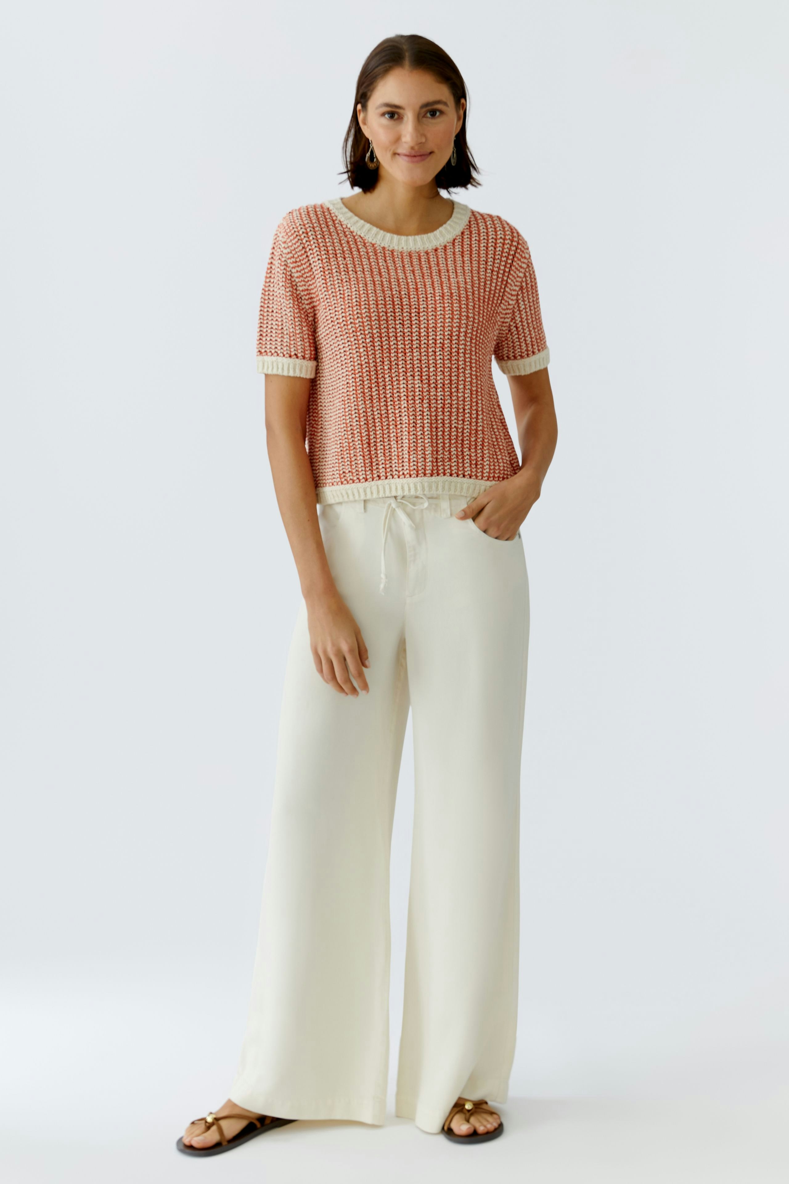 Casual women's pullover: Young woman in a short-sleeve, knitted pullover with a relaxed fit.