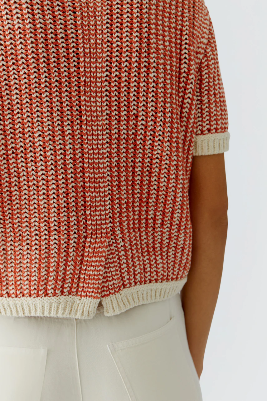 Casual women's pullover: A woman in a short-sleeved, red knitted pullover with a relaxed fit.