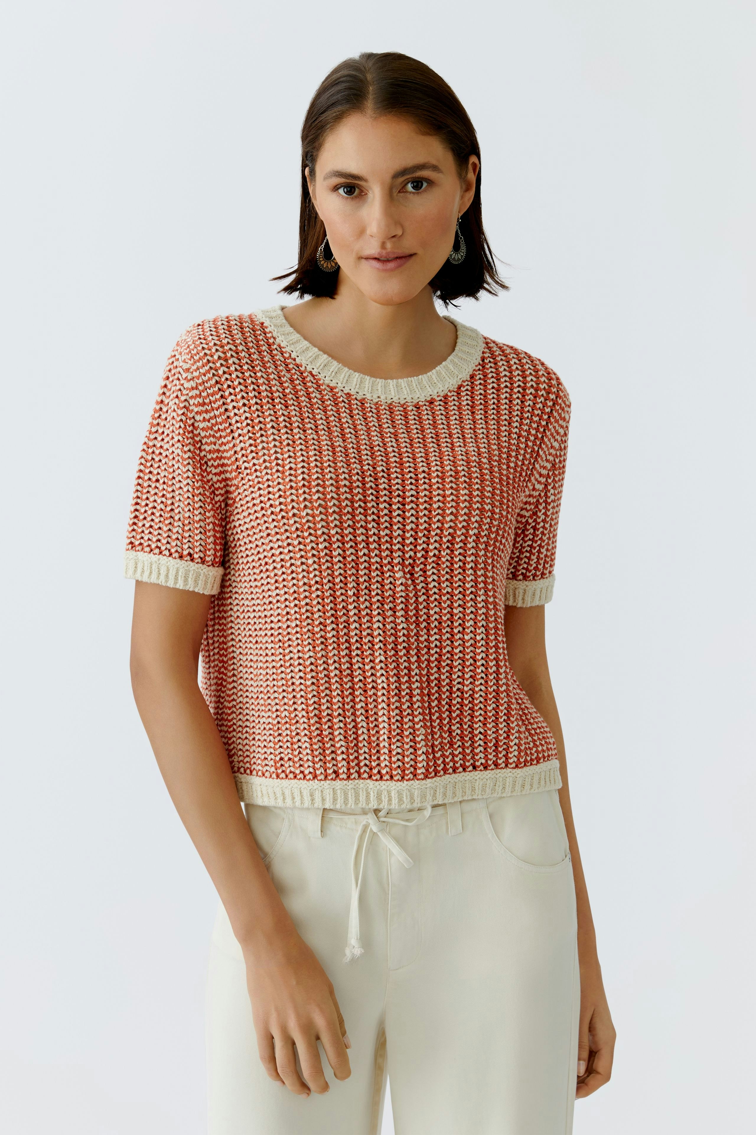 Casual women's pullover: Young woman in a red knitted pullover with short sleeves and a relaxed fit.
