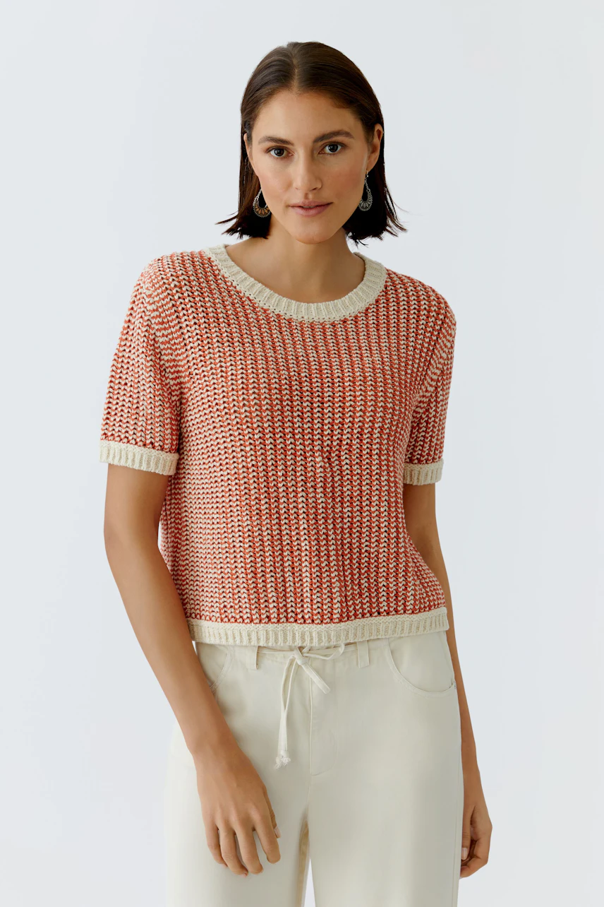 Casual women's pullover: Young woman in a red knitted pullover with short sleeves and a relaxed fit.
