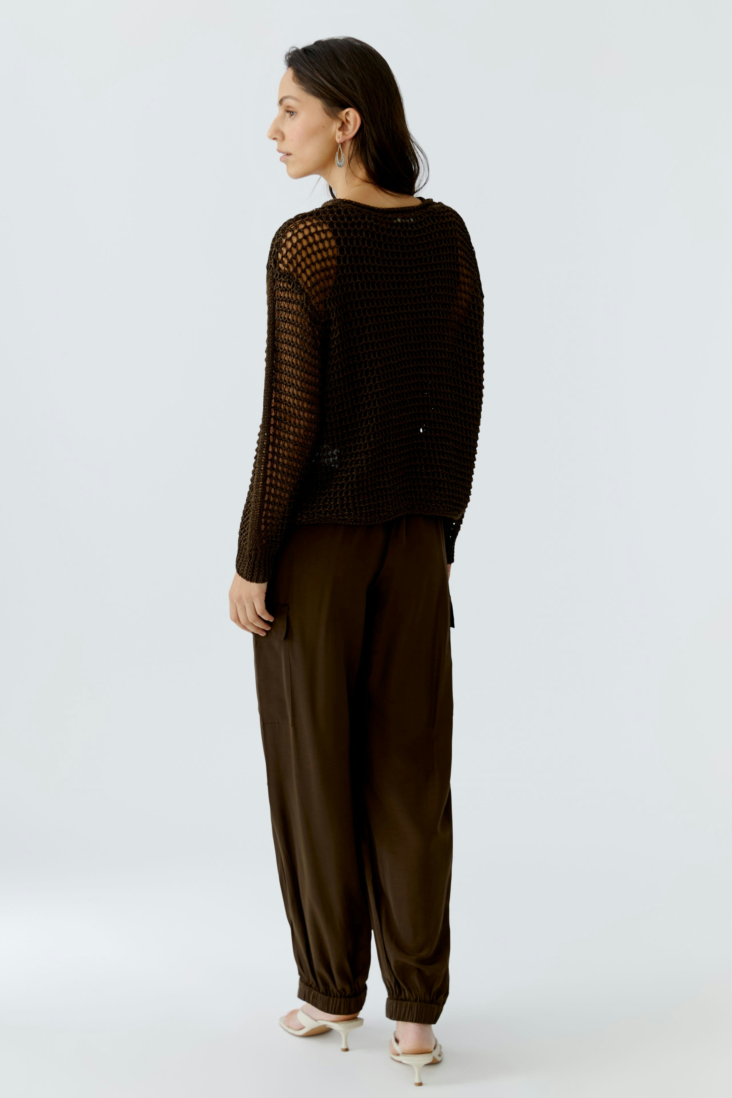 Damen-Pullover: Frau in schwarzem, luftigen Strickpullover mit lockerer Passform und lässigen Hosen.