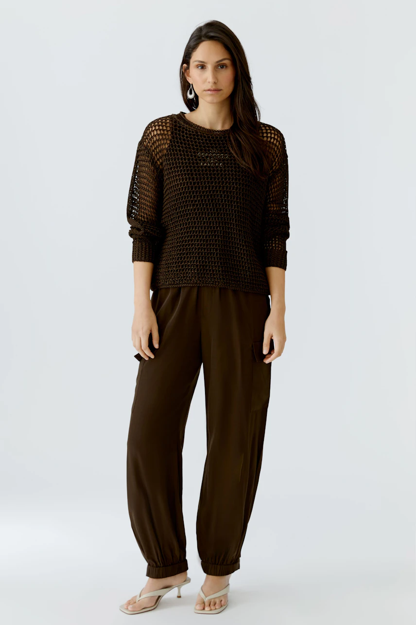 Casual women's pullover: A woman in a black knitted pullover with a relaxed fit stands confidently.