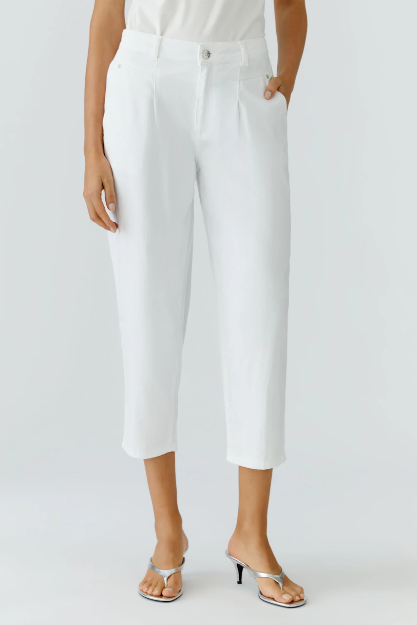 Casual women's jeans: A woman in white barrel jeans with a relaxed fit, paired with stylish sandals.