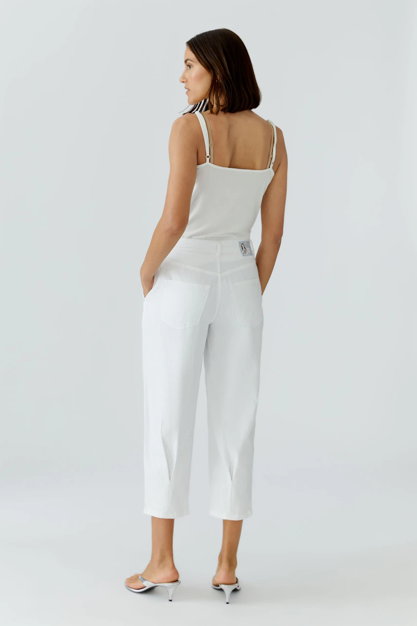 Casual women's jeans: A woman in white barrel jeans with a simple top, showcasing a relaxed fit.