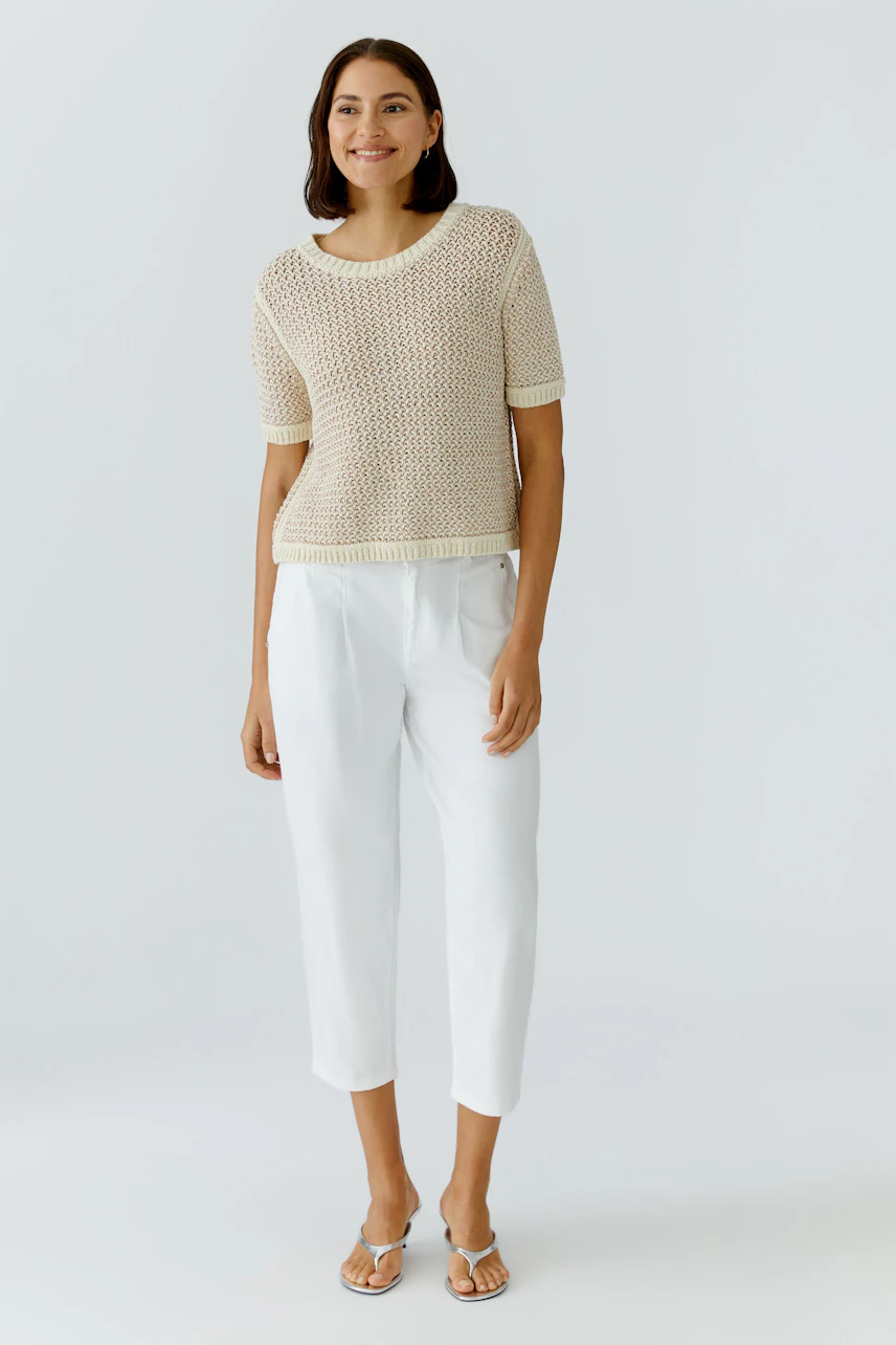 Casual women's jeans barrel: A woman in light-colored jeans barrel and a knitted top stands confidently.