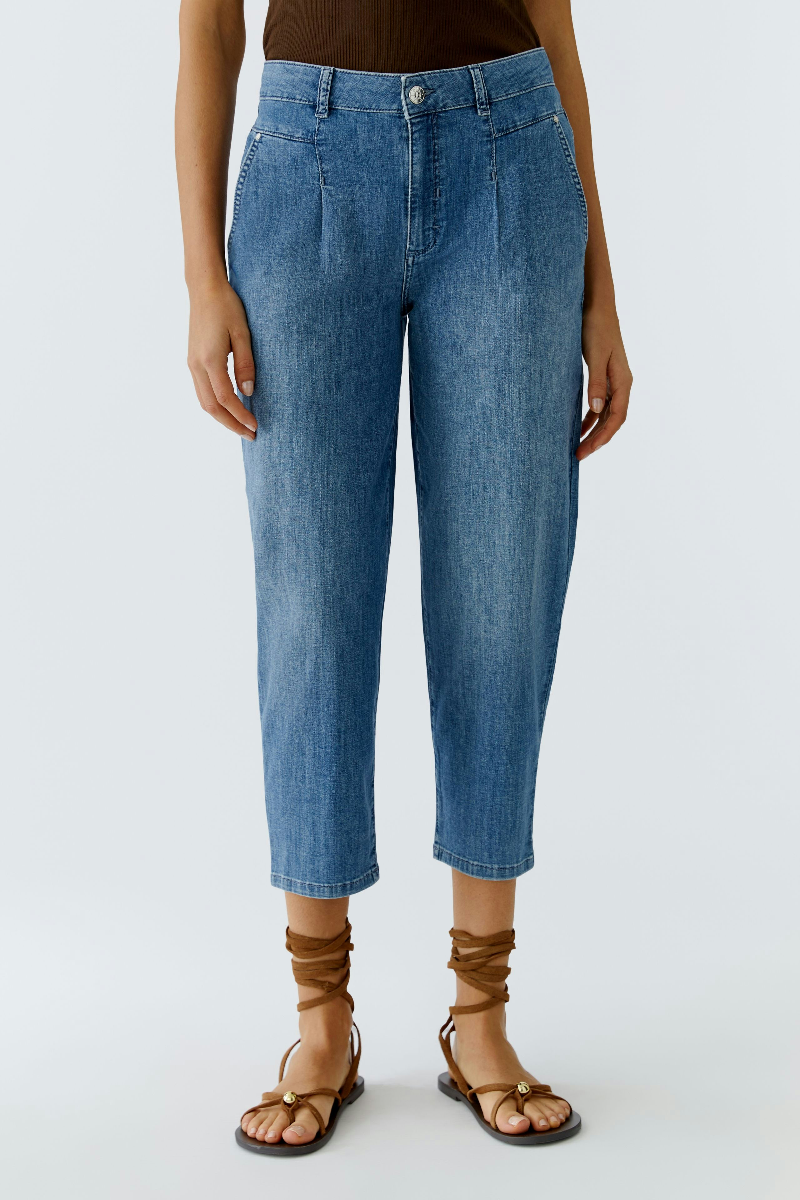 Casual women's jeans: A woman in light blue barrel jeans paired with stylish sandals.