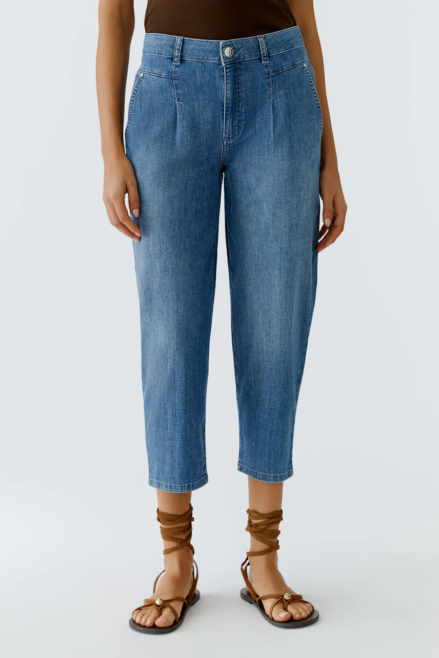 Casual women's jeans: A woman in light blue barrel jeans paired with stylish sandals.