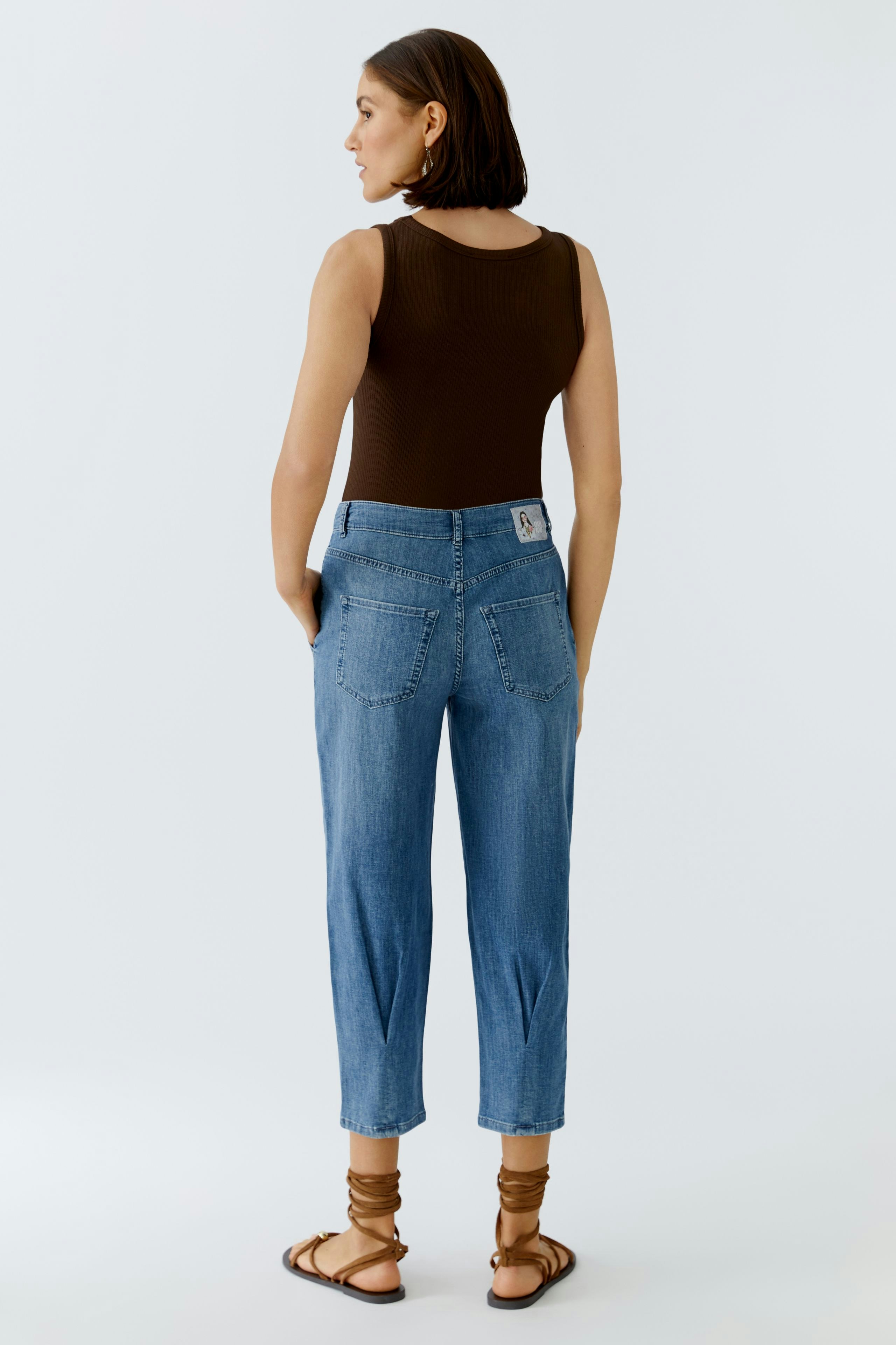 Casual women's jeans barrel: A woman in blue jeans with a relaxed fit and back pockets.