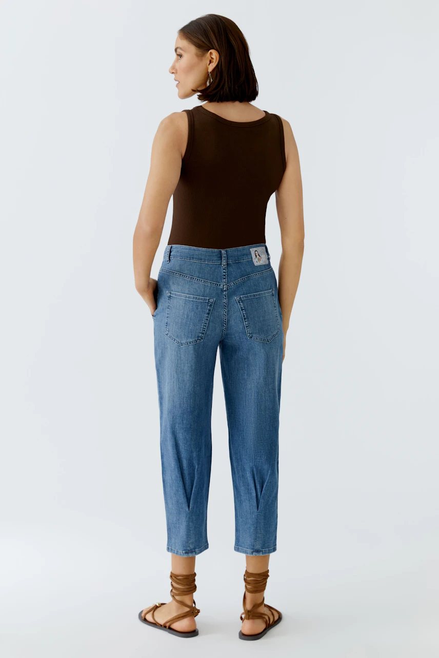 Casual women's jeans barrel: A woman in blue jeans with a relaxed fit and back pockets.