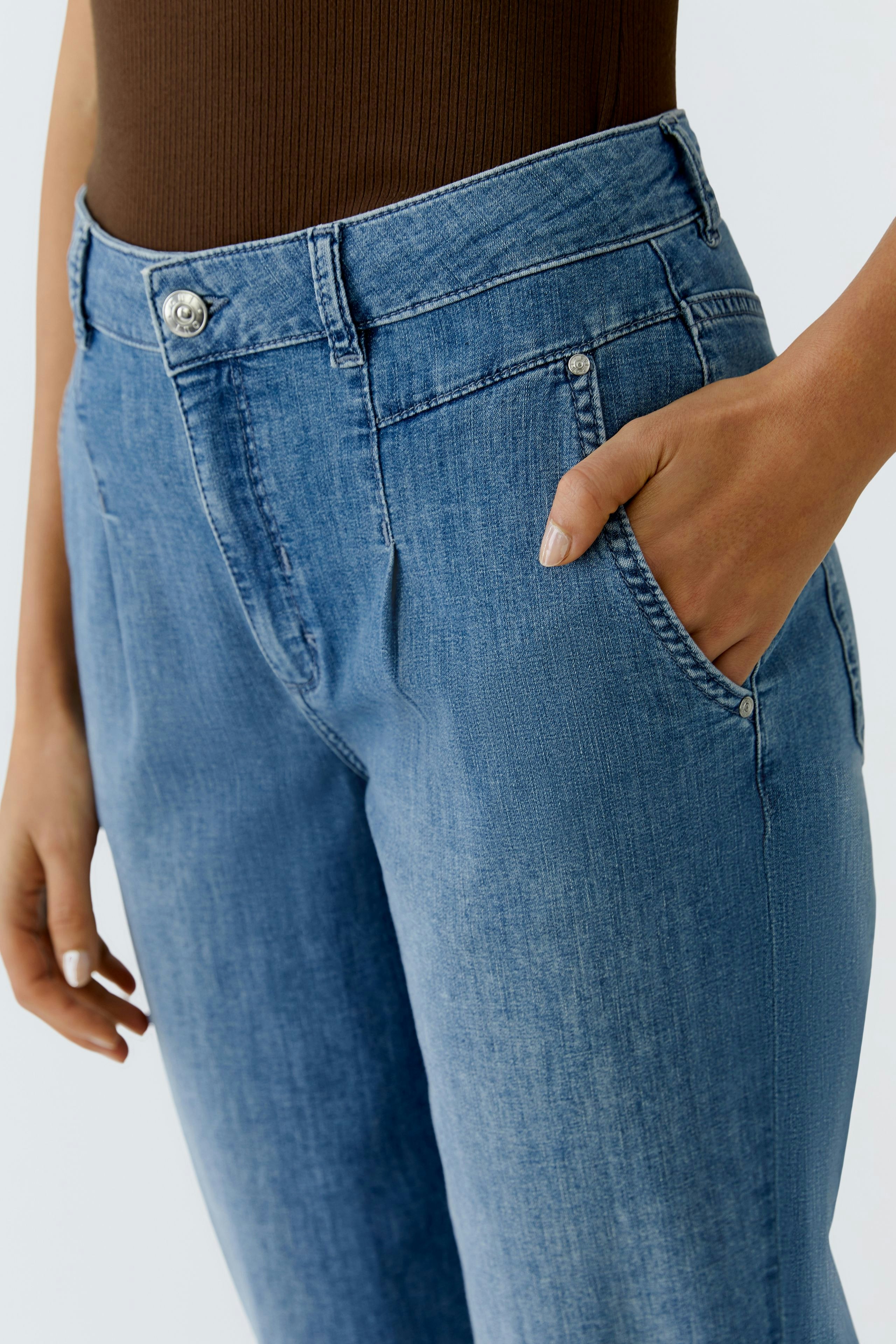Casual women's jeans: Close-up of a woman wearing light blue barrel jeans with a comfortable fit.